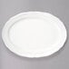A white Tuxton oval platter with a scalloped edge.