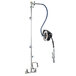 A T&S wall mounted hose reel with hose and nozzle attached to it.