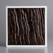 A white square china plate with black and brown designs.
