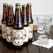 A close-up of a row of Reading Soda Works White Birch bottles next to a glass of water.