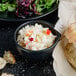 A bowl of rice and Spring Glen Fresh Foods Pepper Cabbage Salad on a table.