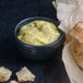 A bowl of Spring Glen Fresh Foods chicken pot pie soup with a spoon next to a baguette.