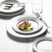 A white Arcoroc Candour porcelain banquet plate with a fork on it.