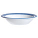 An Arcoroc white opal fruit bowl with a blue rim.