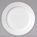 A close-up of a white Arcoroc porcelain side plate with a wavy design.