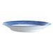An Arcoroc opal soup plate with a blue and white brush design.