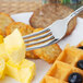 A Oneida European table fork on a plate of waffles with butter and blueberries.