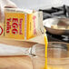 A person pouring Newburg Egg sugared egg yolk into a measuring cup.