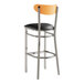 A Lancaster Table & Seating bar stool with a black vinyl seat and chrome legs.