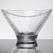 An Arcoroc clear glass bowl with a curved rim on a white surface.