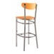 A Lancaster Table & Seating bar stool with a clear coat and cherry wood seat and back on a metal frame.