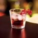 An Arcoroc old fashioned glass with a drink and ice.