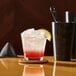 A customizable Arcoroc rocks glass with a drink on a table.