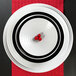 A white round melamine plate with a swirled design on it.