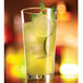 A stackable Arcoroc beverage glass filled with limeade and garnished with lime slices and mint.