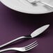 A close-up of a Oneida Apex stainless steel salad/dessert fork on a purple table.