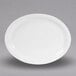 A white Elite Global Solutions oval melamine plate on a gray surface.