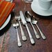 A close-up of a Oneida Satin Astragal stainless steel dessert fork on a table.