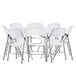 A Lancaster Table & Seating white heavy-duty plastic folding table surrounded by white folding chairs.