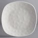 An Elite Global Solutions Tenaya off white square melamine plate with rounded edges.