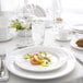 A white bone china bread and butter plate with food on it.