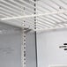 A white shelf with metal hooks on the wall.