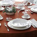 A table set with white Chef & Sommelier Infinity bone china pasta bowls and white plates on a table in a fine dining restaurant.