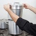 A man using a Vollrath aluminum inset for a double boiler over a stove.