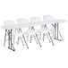 A Lancaster Table & Seating white folding table with chairs.