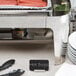 A Tablecraft stainless steel cylinder card holder on a table with hot dogs.