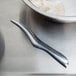 A bowl of raw shrimp next to a knife.