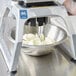 A Vollrath Redco InstaCut 3.5 wedging a bowl of fruit and vegetables on a countertop.