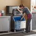 A woman putting a bottle of water into a Manitowoc ice storage bin.