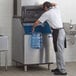 A man filling a container with ice from a Manitowoc ice storage bin.