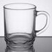 An Arcoroc clear glass mug with a handle on a table.