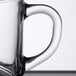 An Arcoroc tempered glass mug with a handle on a table.