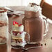 Three Arcoroc mason jars filled with desserts on a table.