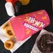 A Solo paper container with fried food inside on a table with a cup of ketchup.