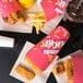 A Solo paper container filled with fries and chicken tenders on a table.