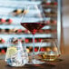 A Chef & Sommelier wine glass filled with red liquid on a table.