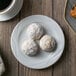 A white Arcoroc bread and butter plate with three cookies and a cup of coffee.