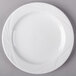 An Arcoroc white porcelain bread and butter plate with a wavy design.