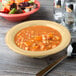 A Diamond Harvest melamine bowl of soup with vegetables next to a bowl of salad.