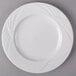 An Arcoroc white porcelain salad plate with a wavy design.