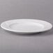 An Arcoroc white porcelain salad plate with a leaf design.