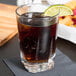 A Libbey Dakota beverage glass filled with soda and ice with a lime wedge on the rim.