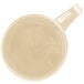 A close-up of a beige Cambro polycarbonate mug.