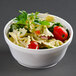 A white Dart foam bowl filled with pasta salad with tomatoes, green and red vegetables.