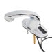 A close-up of a T&S chrome hands-free sensor faucet with a cast spout.