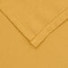 A close up of a yellow rectangular poly/cotton table cover with hemmed edges.